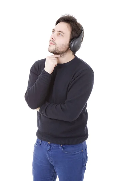 白い背景に隔離されたヘッドフォンで音楽を聴くカジュアルな若者 — ストック写真