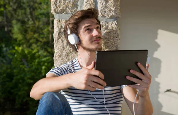 Junger Mann Entspannt Mit Einem Tablet Musik Hören Mit Kopfhörern — Stockfoto