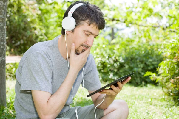 Giovane Uomo Che Rilassa Con Tablet Ascoltando Musica Con Cuffie — Foto Stock