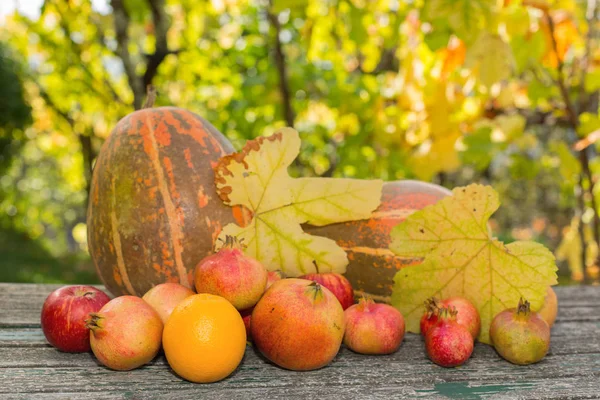 Осенние фрукты на деревянном столе, на открытом воздухе — стоковое фото