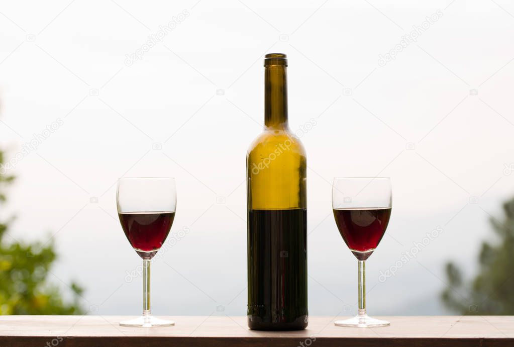 wine bottle and glass on wooden table, outdoor