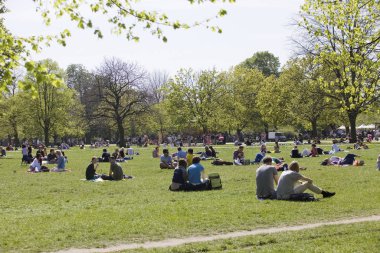 İnsanlar rahatlatıcı öğleden sonra sırasında parkta büyük miktarda