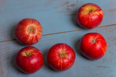 eski mavi ahşap masa üzerinde kırmızı elma