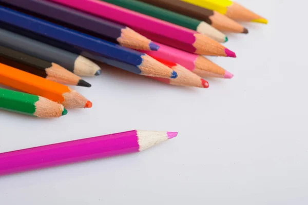 Цветные деревянные карандаши на белой бумаге — стоковое фото