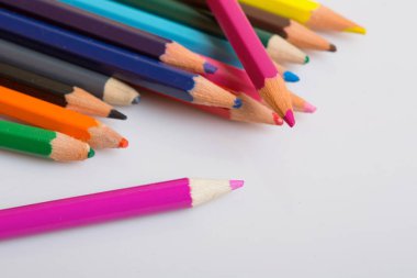 Bir beyaz kağıt üzerinde renkli ahşap kalemler