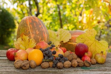 Sonbahar meyveleri ahşap bir masada, açık havada.