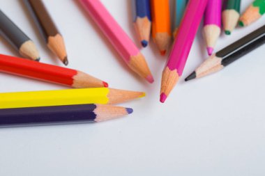 Bir beyaz kağıt üzerinde renkli ahşap kalemler