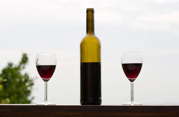 Butelka wina i szkło na drewniany stół, ogrodowy — Zdjęcie stockowe