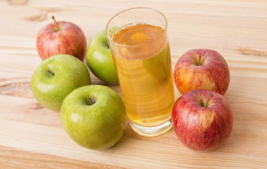 ahşap bir masada elma ve elma suyu