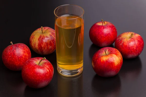 Ποτήρι χυμό μήλου και ένα κόκκινα μήλα — Φωτογραφία Αρχείου