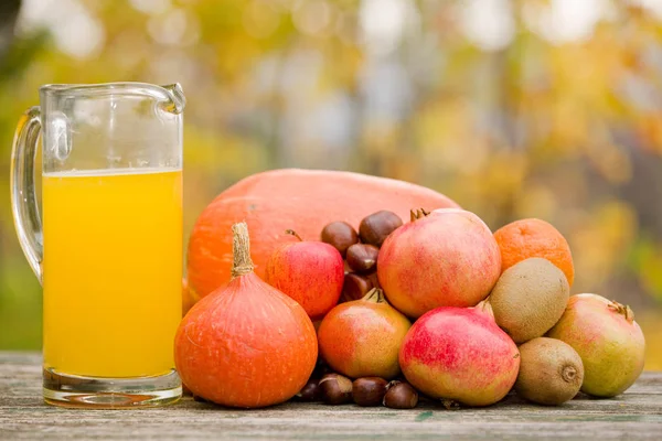 Gläser Saft und jede Menge Herbstfrüchte — Stockfoto