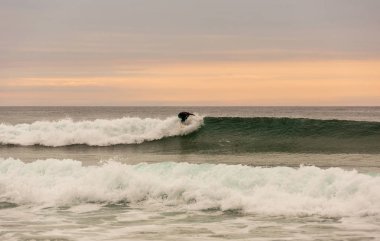Gün batımında sörfçü