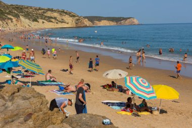 VILA DO BISPO, PORTUGAL: Vila do Bispo 'daki ünlü Salema plajında insanlar. Bu plaj Algarve 'nin ünlü turistik bölgesinin bir parçasıdır..