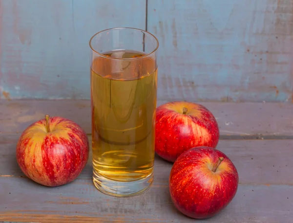 Glas Apfelsaft Und Rote Äpfel Auf Blauem Alten Holzgrund — Stockfoto