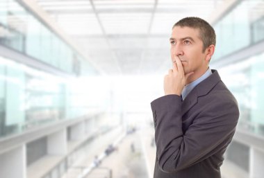 Genç bir iş adamı, ofiste düşünüyor.