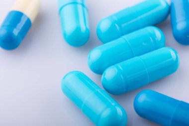 Haplar, kapsül yığını, karışık terapi ilaçları, beyaz bir arka plan.