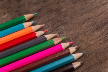 Eski ahşap bir arka planda tahta renkli kalemler.
