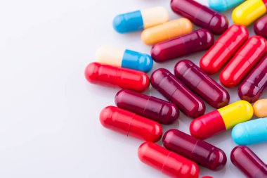 Haplar, kapsül yığını, karışık terapi ilaçları, beyaz bir arka plan.