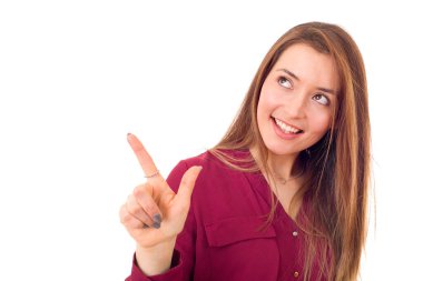 Genç, mutlu, güzel bir kadın işaret ediyor, beyazlar içinde.