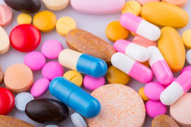 Haplar, kapsül yığını, karışık terapi ilaçları, beyaz bir arka plan.