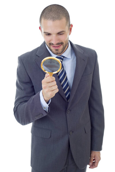 Isolated young business man with magnifying glass