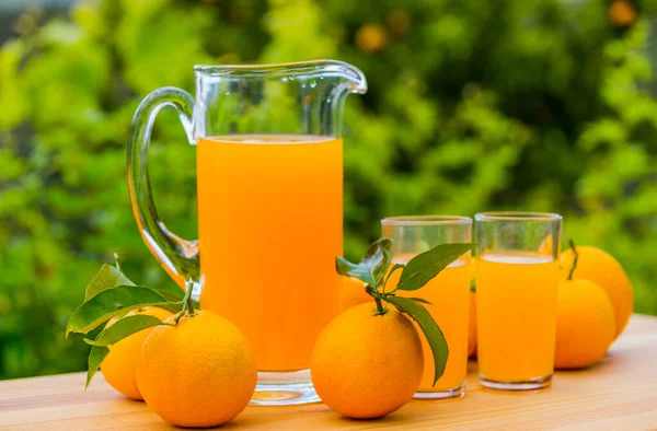 Orangensaft Und Orangen Auf Dem Tisch Garten — Stockfoto