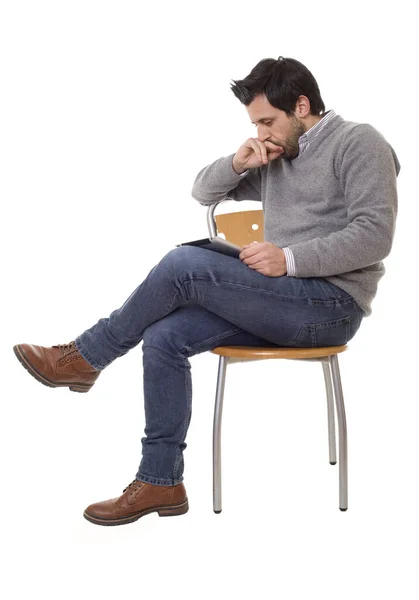 快乐而随意的男人 坐在椅子上 带着平板电脑 与白色背景隔离 — 图库照片
