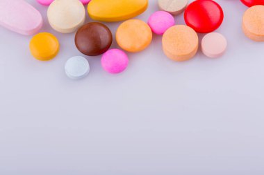 Haplar, kapsül yığını, karışık terapi ilaçları, beyaz bir arka plan.