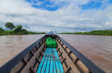 Myanmar 'daki Inle Gölü' nü eski ve paslı bir tekneyle keşfediyor.
