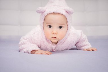 yakın çekim küçük bebek kulakları ile bir takım elbise onun karnında yatan şaşırttı