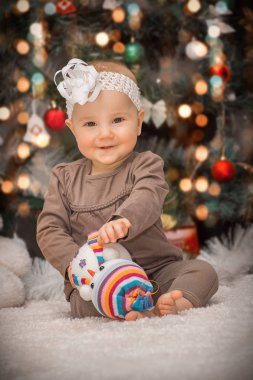 portre küçük bebek arka planı yumuşak oyuncaklar Noel ağacının altında karın üzerinde yalan söylüyor