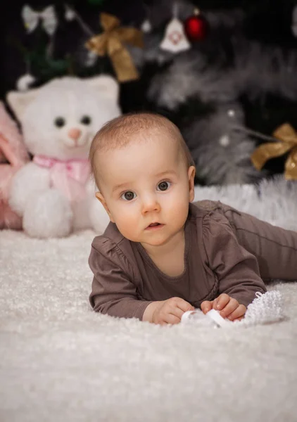 Retrato Pouco Bebê Está Deitado Barriga Sob Árvore Natal Fundo — Fotografia de Stock