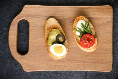 Açık yüzlü sandviç kanepe veya crostini bir ahşap hizmet kurulu