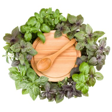 Kaşık ile yuvarlak ahşap kesme tahtası. Çeşitli fesleğen bitki 