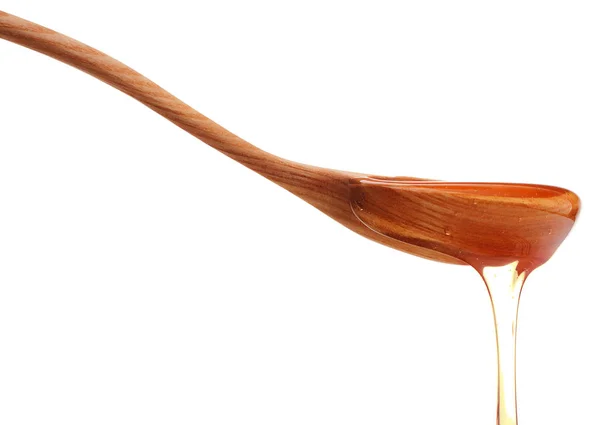 Honey dripping from a wooden honey dipper isolated on white back — Stock Photo, Image