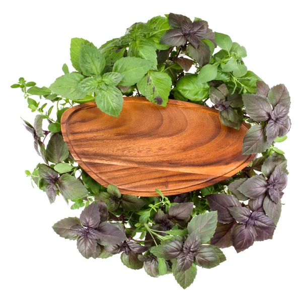 Пустая деревянная тарелка на различных сладких трав базилика листья backgrou — стоковое фото