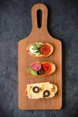 Açık yüzlü sandviç kanepe veya crostini bir ahşap hizmet kurulu