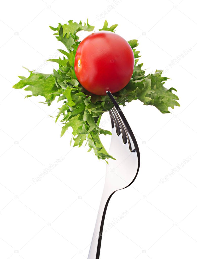 Fresh lettuce salat leaves and cherry tomato on fork isolated on white background cutout.