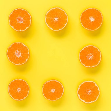 Taze mandalina dilimleri sarı zemin üzerine meyve deseni. Düz yatıyordu, en iyi görünüm. Pop sanat tasarım, yaratıcı yaz konsepti. Minimal tarzda narenciye yarısı. Mandalina.