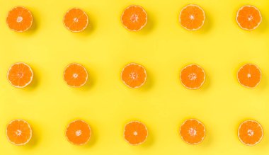 Taze mandalina dilimleri sarı zemin üzerine meyve deseni. Düz yatıyordu, en iyi görünüm. Pop sanat tasarım, yaratıcı yaz konsepti. Minimal tarzda narenciye yarısı. Mandalina.