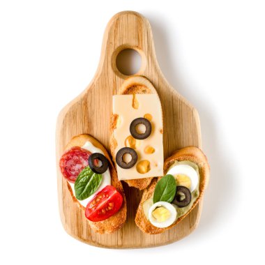 Açık yüzlü sandviç kanepe veya crostini beyaz arka plan closeup izole bir ahşap hizmet gemide. Üstten görünüm.