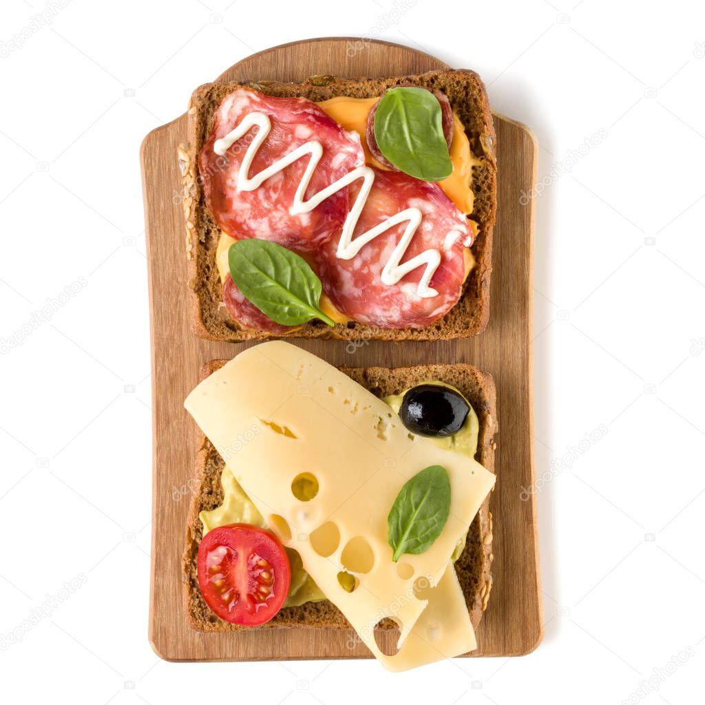 Open  faced sandwich canape or crostini on a wooden serving board  isolated on white background closeup. Top view.