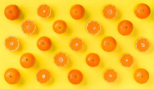 Fruit pattern of fresh mandarin slices on yellow background.