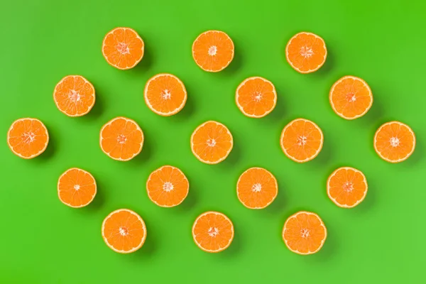 Fruit pattern of orange slices on green background.