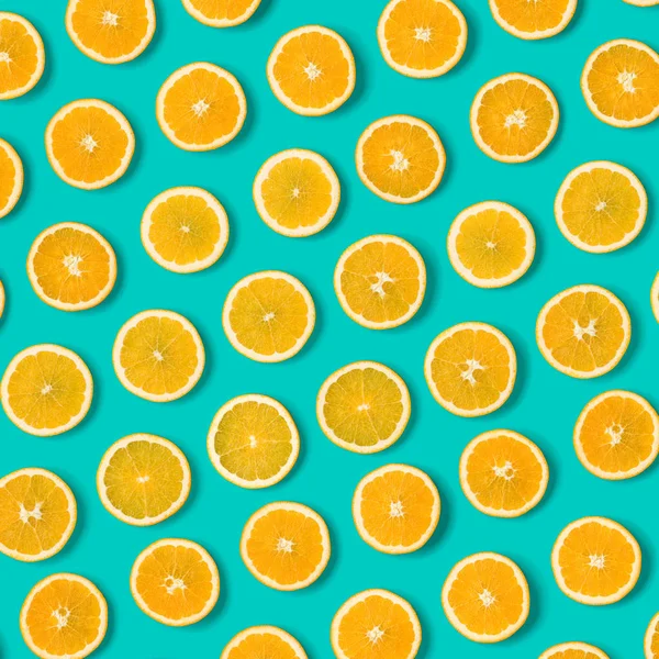 Fruit pattern of orange slices on blue background. Flat lay, top view. Food background.