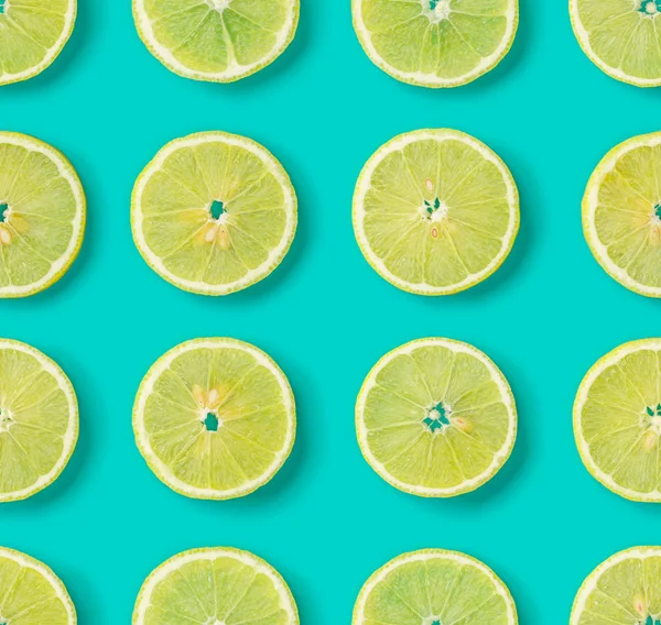 Fruit pattern of lemon slices on blue background. Flat lay, top
