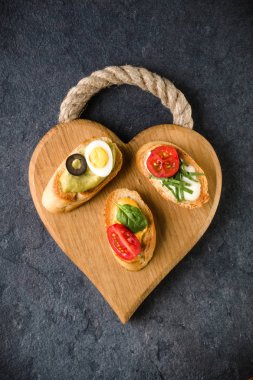 Açık yüzlü sandviç kanepe veya crostini bir ahşap hizmet kurulu