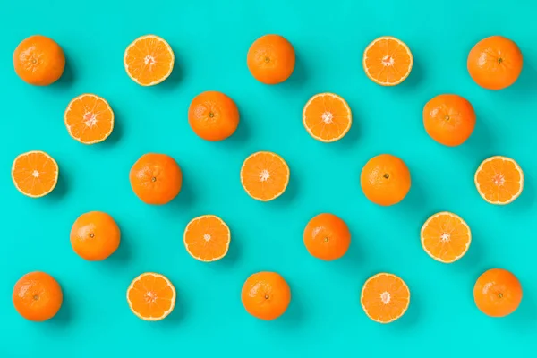 Fruit pattern of fresh mandarin slices on blue background. Flat