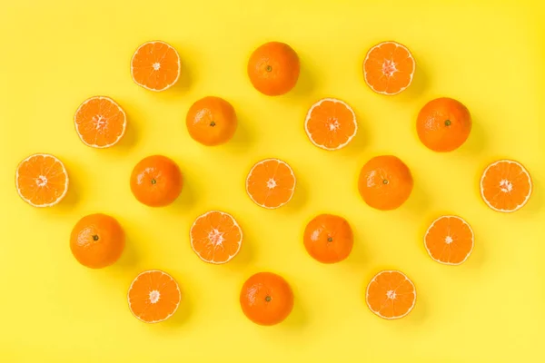 Fruit pattern of fresh mandarin slices on yellow background. Fla