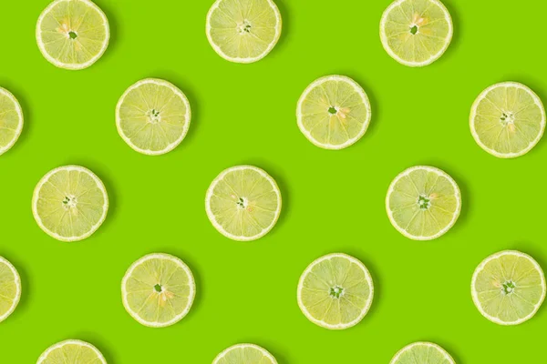 Fruit pattern of lemon slices on green background. Flat lay, top — Stock Photo, Image